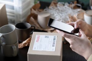 Person scanning shipping label code on mobile.